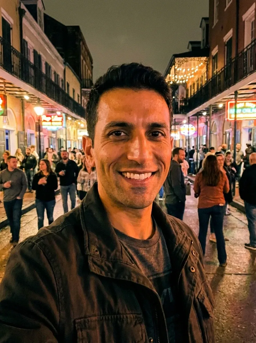 Original selfie input — smiling man in a dark jacket on a night street